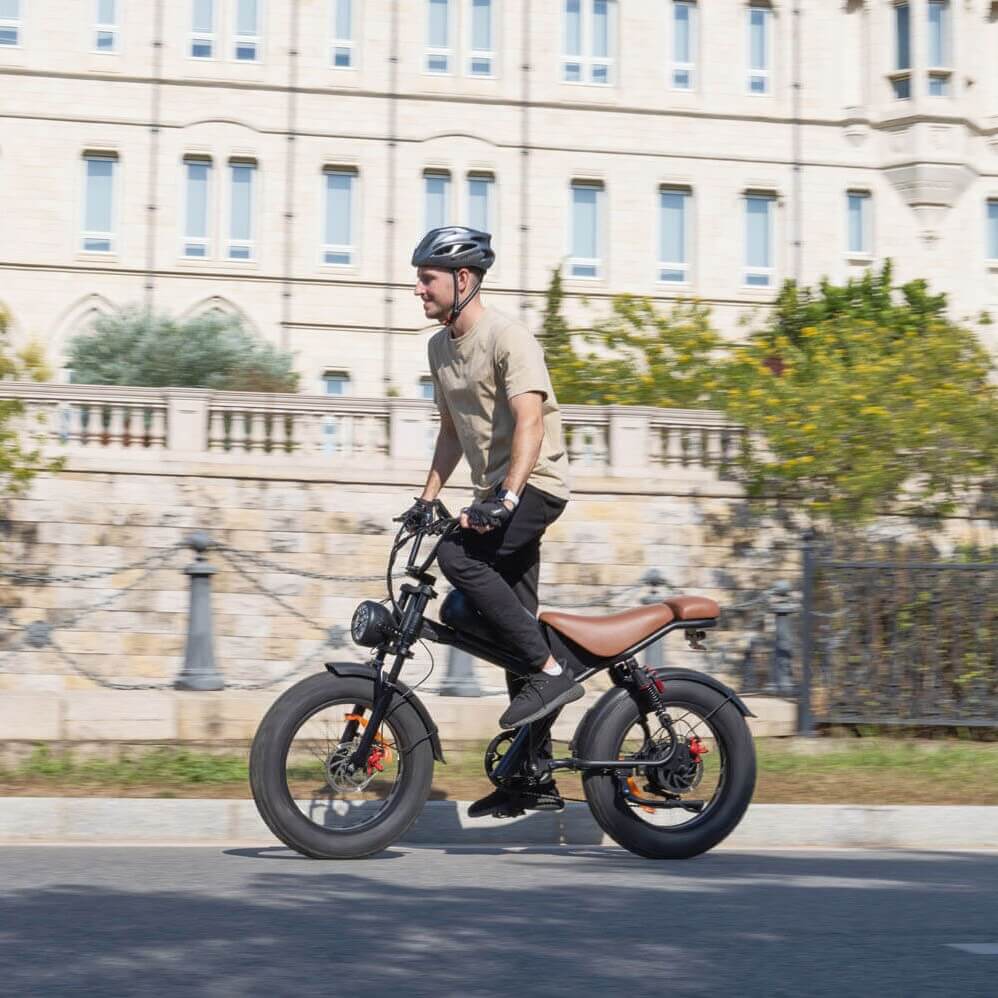 Man riding Emoko off-road fat tire electric bicycle on city street with safety helmet