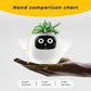 EMOKO smart pet planter robot held in hand showing size with green plant on top and digital face display